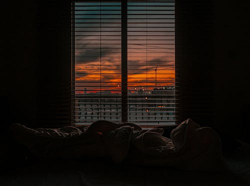 Free Crumpled blanket in dark room at sunset Stock Photo